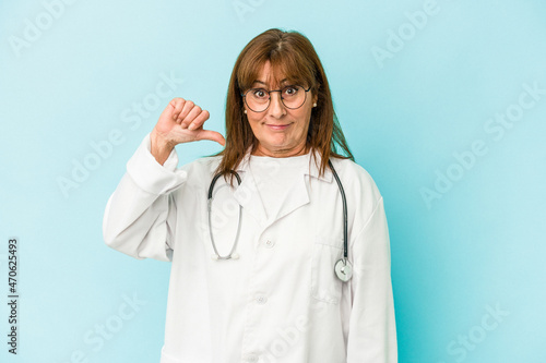 Middle age doctor woman isolated on pink background showing a dislike gesture  thumbs down. Disagreement concept.