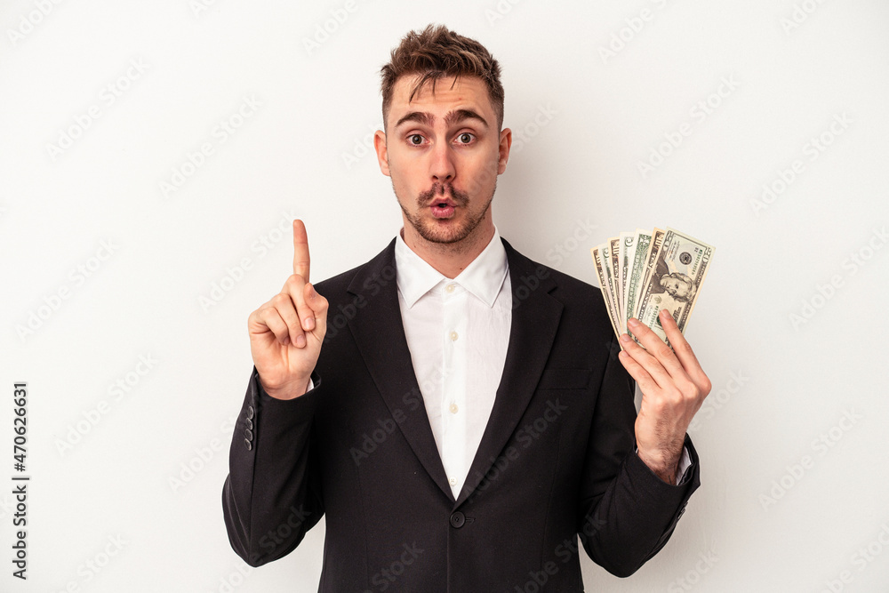 Young caucasian business man holding bank notes isolated on white background having some great idea, concept of creativity. Young caucasian business man holding bank notes isolated on white background having some great idea, concept of creativity.