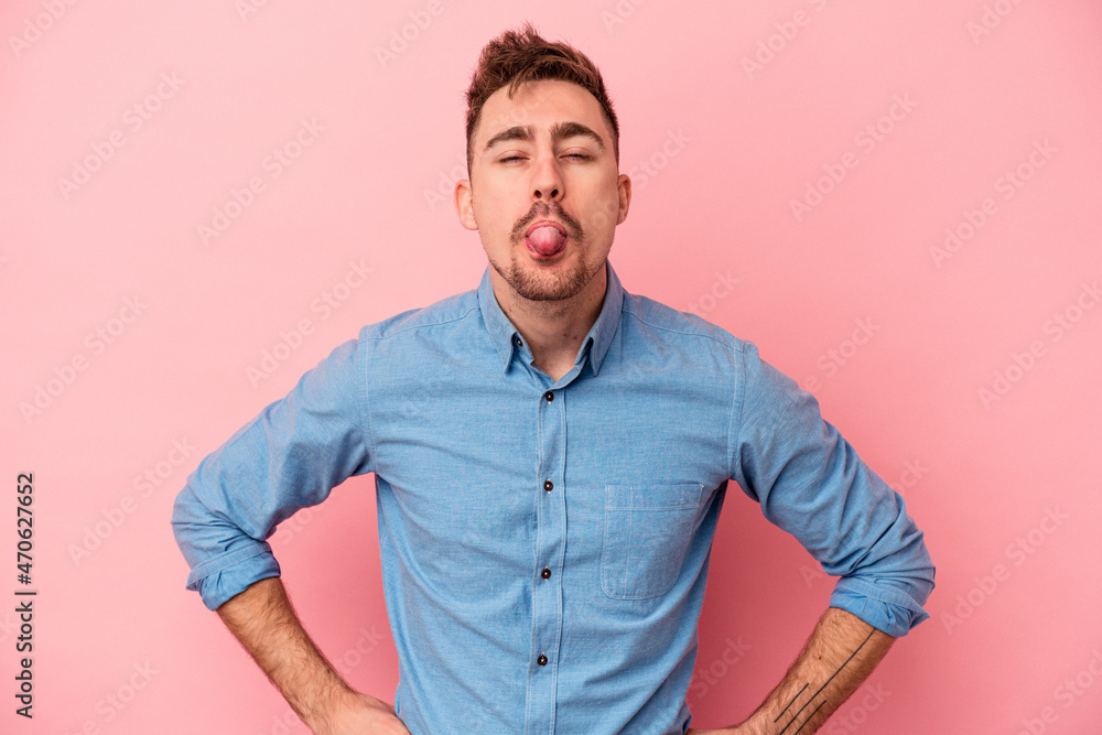 Young caucasian man isolated on pink background funny and friendly sticking out tongue. Young caucasian man isolated on pink background funny and friendly sticking out tongue.