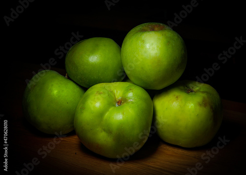 Bunch of five green apples (Granny Smith, Golden, Pippin, Crispin) isolated on a wooden table photo