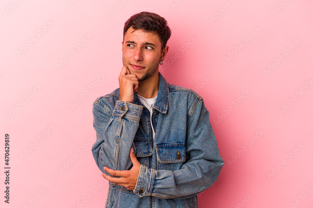 Fototapeta premium Young caucasian man with tattoos isolated on yellow background relaxed thinking about something looking at a copy space.