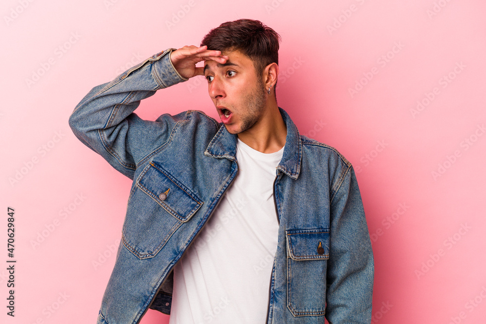 Young caucasian man with tattoos isolated on yellow background looking far away keeping hand on forehead. Young caucasian man with tattoos isolated on yellow background looking far away keeping hand on forehead.