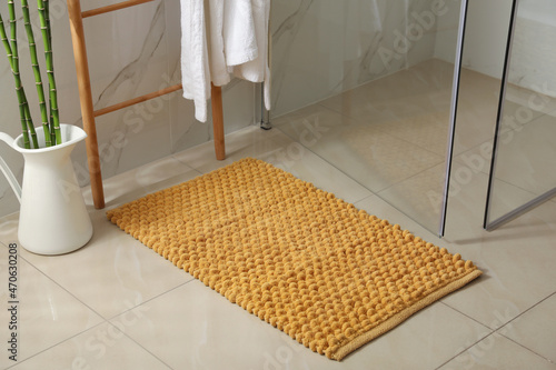 Fotografie Soft orange bath mat on floor indoors