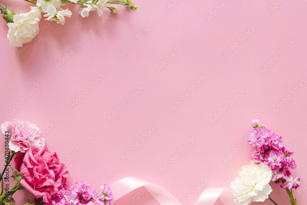 Fototapeta premium Summer and spring pink frame decorated with beautiful flowers with empty space for text. Pink roses and white carnation