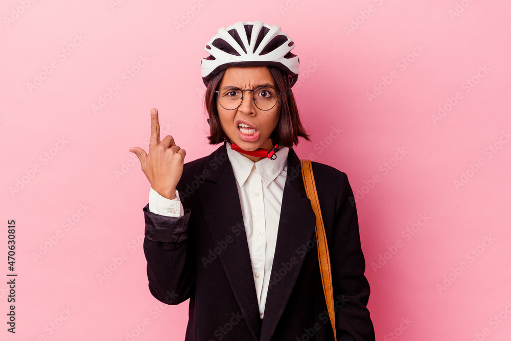 Young business mixed race woman wearing a bike helmet isolated on pink background showing a disappointment gesture with forefinger. Young business mixed race woman wearing a bike helmet isolated on pink background showing a disappointment gesture with forefinger.