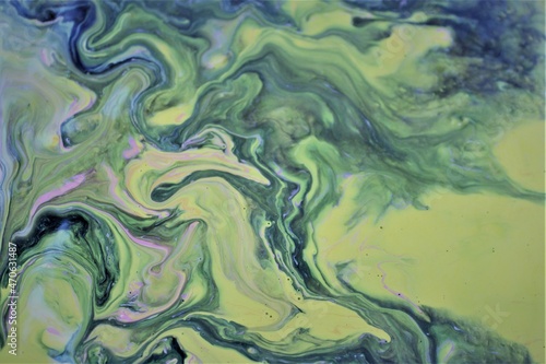 Abstract background of yellow-green marble. Multicolored spots of acrylic paint, freely flowing and creating an interesting pattern. Bright color. Background for the cover of a book, laptop.