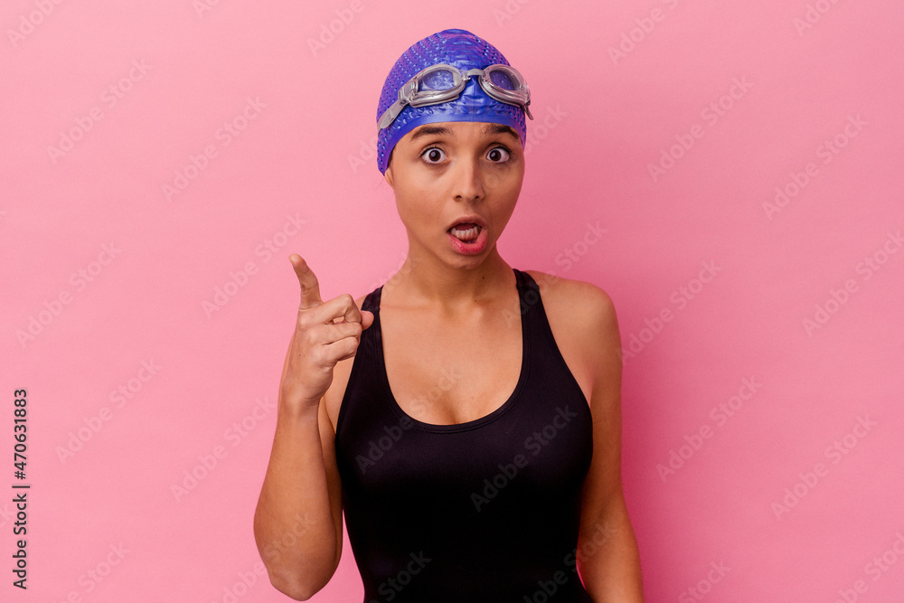 Young swimmer mixed race woman isolated on pink background having an idea, inspiration concept. Young swimmer mixed race woman isolated on pink background having an idea, inspiration concept.