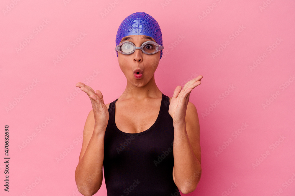 Young latin swimmer woman wearing diving googles and cap excited ready to swim Young latin swimmer woman wearing diving googles and cap excited ready to swim