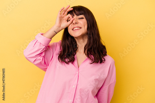 Young caucasian woman isolated on yellow background excited keeping ok gesture on eye.