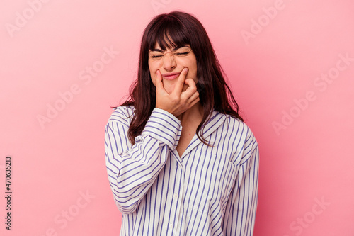 Young caucasian woman isolated on pink background doubting between two options. © Asier
