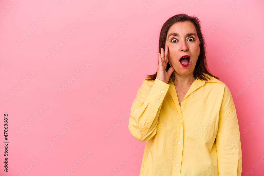 Middle age caucasian woman isolated on pink background shouts loud, keeps eyes opened and hands tense. Middle age caucasian woman isolated on pink background shouts loud, keeps eyes opened and hands tense.