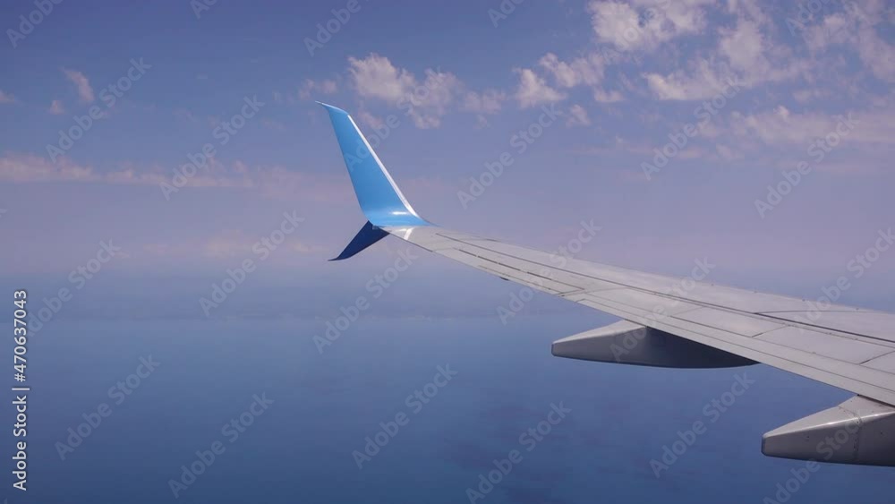 Airplane flight. Wing of an airplane flying above the clouds. View from the window of the plane Airplane flight. Wing of an airplane flying above the clouds. View from the window of the plane