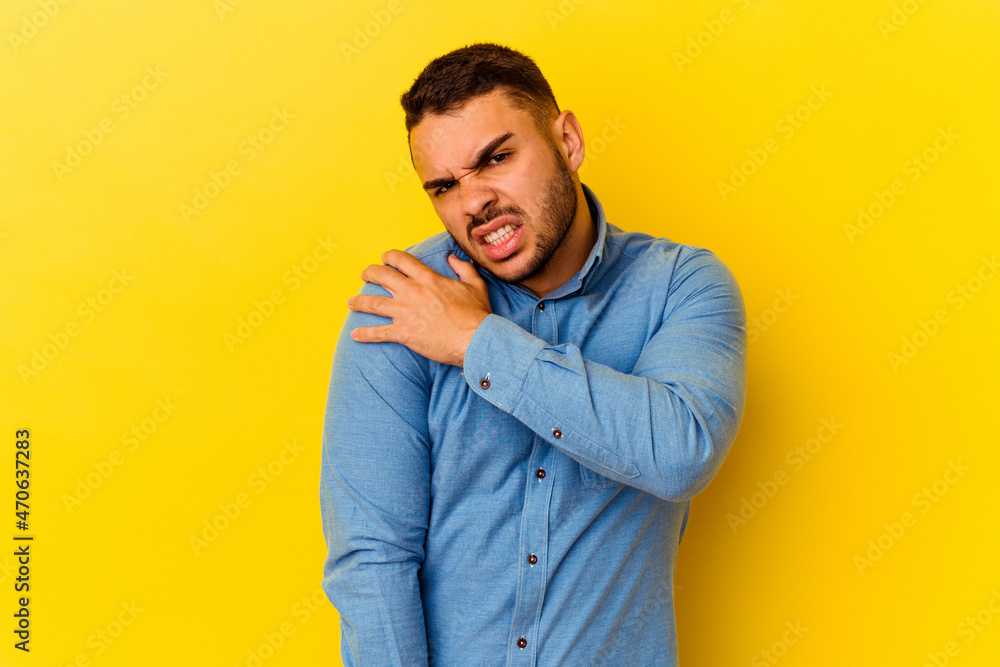 Young caucasian man isolated on yellow background having a shoulder pain. Young caucasian man isolated on yellow background having a shoulder pain.