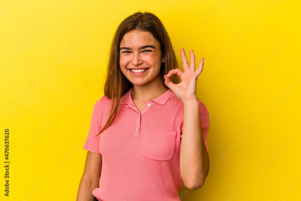 Young caucasian woman isolated on yellow background cheerful and confident showing ok gesture. Young caucasian woman isolated on yellow background cheerful and confident showing ok gesture.