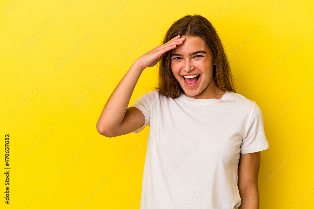Young caucasian woman isolated on yellow background shouts loud, keeps eyes opened and hands tense. Young caucasian woman isolated on yellow background shouts loud, keeps eyes opened and hands tense.