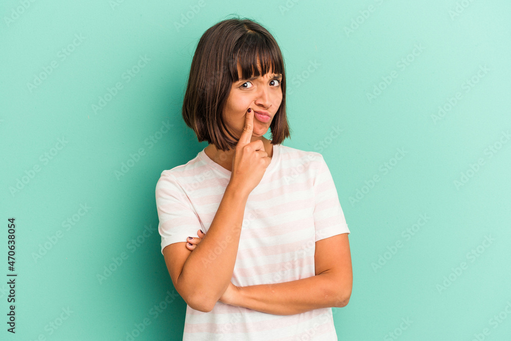 Young mixed race woman isolated on blue unhappy looking in camera with sarcastic expression. Young mixed race woman isolated on blue unhappy looking in camera with sarcastic expression.