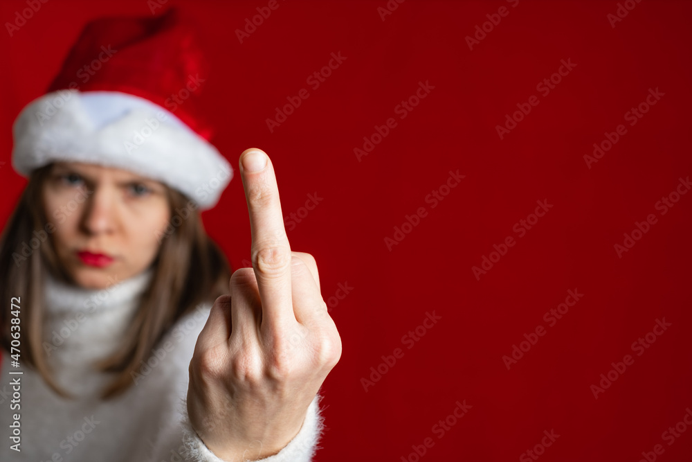 Fuck haters show sign. Portrait crazy girl on x-mas, isolated red color background Fuck haters show sign. Portrait crazy girl on x-mas, isolated red color background