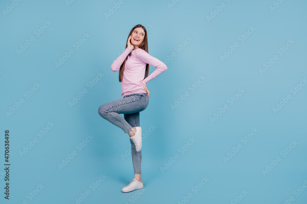 Full length profile side photo of young excited girl happy positive smile look empty space isolated over blue color background