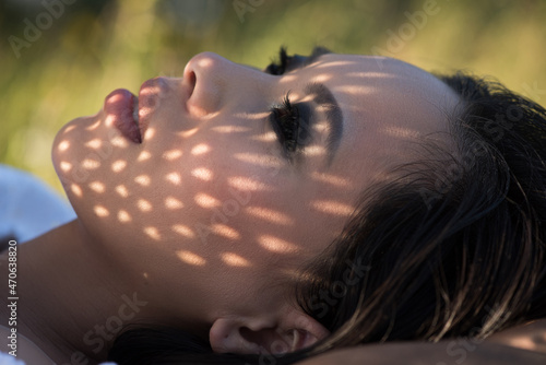 Portrait young woman lying on grass