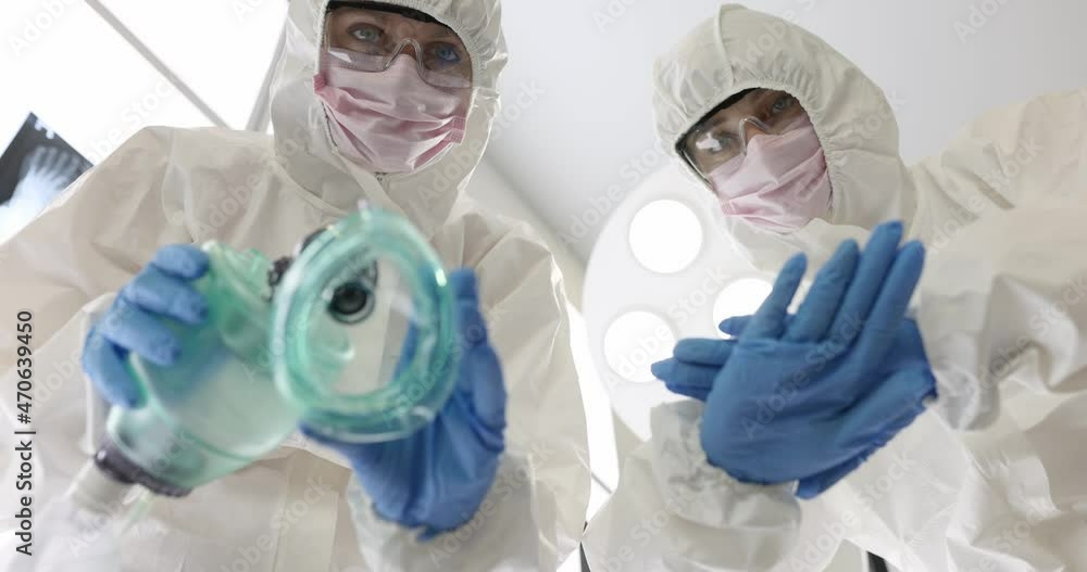 Two doctors in protective suits and masks holding oxygen mask and planning to have heart massage slow motion 4k movie Two doctors in protective suits and masks holding oxygen mask and planning to have heart massage slow motion 4k movie
