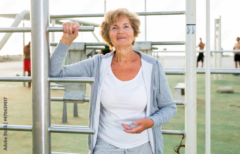 Portrait of positive elderly woman in sportswear on beach Portrait of positive elderly woman in sportswear on beach