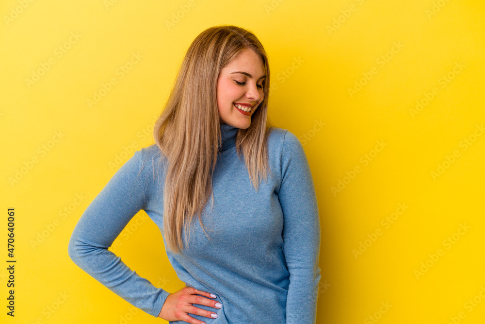 Young russian woman isolated on yellow background laughs and closes eyes, feels relaxed and happy. Young russian woman isolated on yellow background laughs and closes eyes, feels relaxed and happy.
