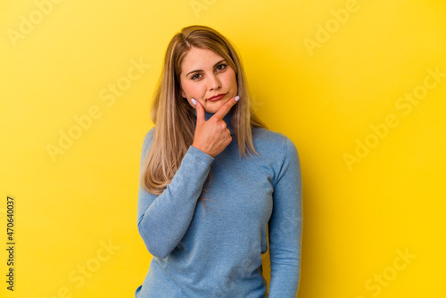 Young russian woman isolated on yellow background contemplating, planning a strategy, thinking about the way of a business.