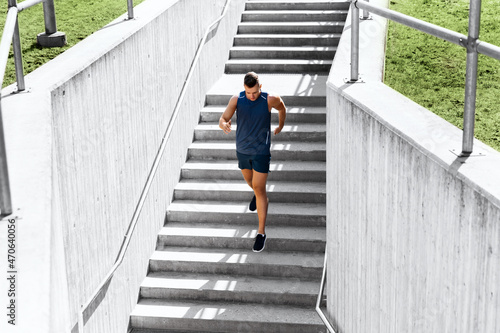 fitness, sport and healthy lifestyle concept - young man running downstairs