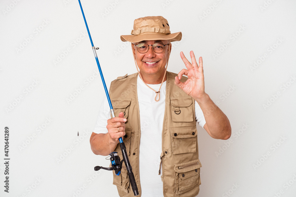 Senior american fisherman holding rod isolated on white background cheerful and confident showing ok gesture. Senior american fisherman holding rod isolated on white background cheerful and confident showing ok gesture.