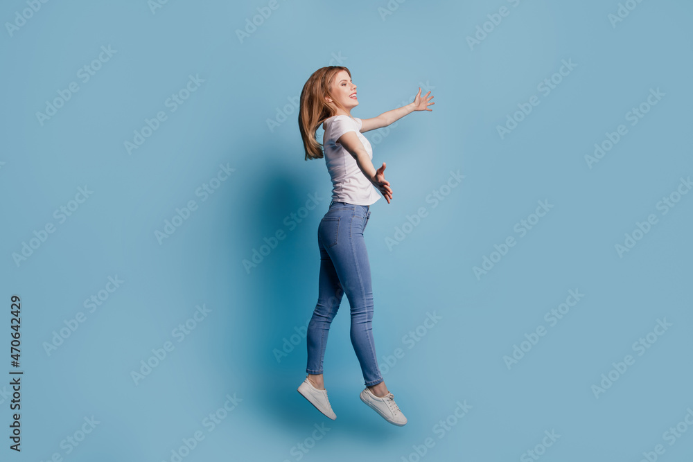 Fototapeta premium Profile photo of inspired lady jump stretch hands invite welcome hug wear casual clothes on blue color background