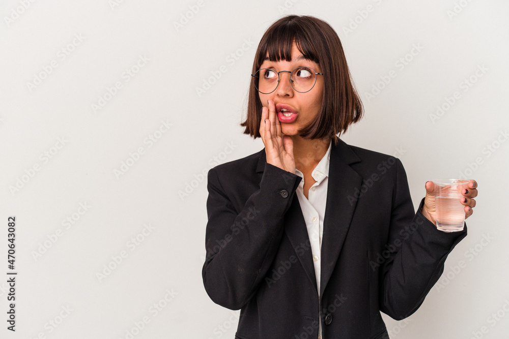 Young mixed race business woman holding a glass of water isolated on white background is saying a secret hot braking news and looking aside Young mixed race business woman holding a glass of water isolated on white background is saying a secret hot braking news and looking aside
