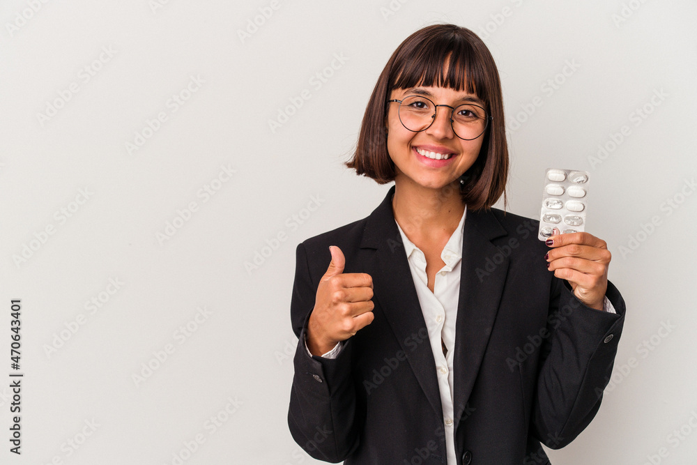 Young mixed race business woman holding pills isolated smiling and raising thumb up Young mixed race business woman holding pills isolated smiling and raising thumb up