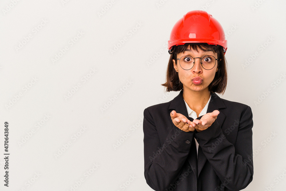 Young architect woman with red helmet isolated on white background folding lips and holding palms to send air kiss. Young architect woman with red helmet isolated on white background folding lips and holding palms to send air kiss.