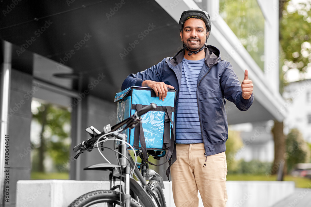food shipping, profession and people concept - happy smiling delivery man with thermal insulated bag and bicycle on city street showing thumbs up