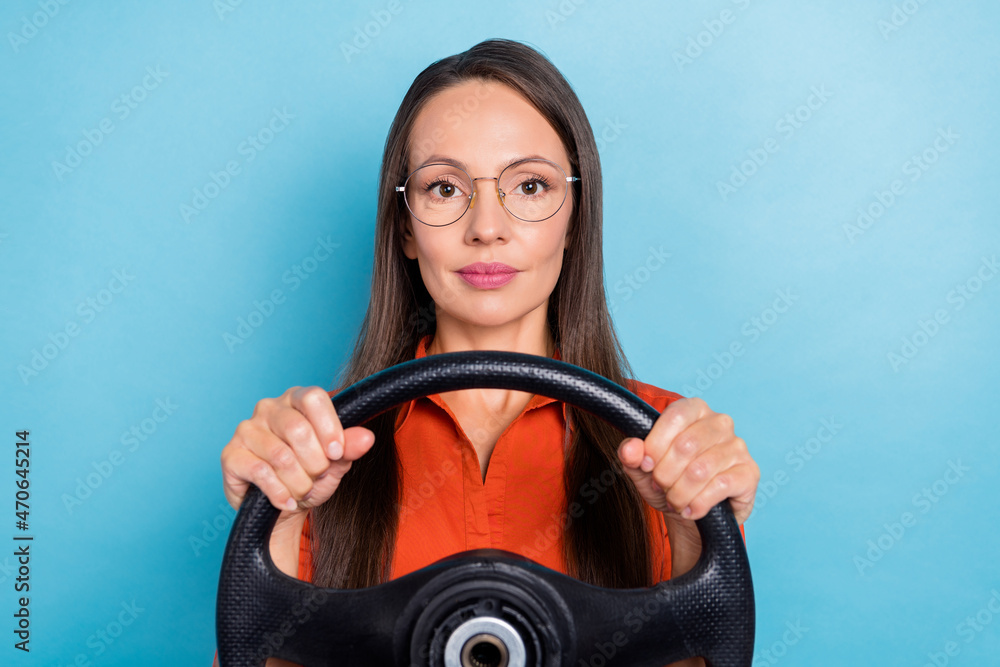 Photo of shiny confident mature lady dressed red shirt glasses smiling holding steering wheel isolated blue color background Photo of shiny confident mature lady dressed red shirt glasses smiling holding steering wheel isolated blue color background
