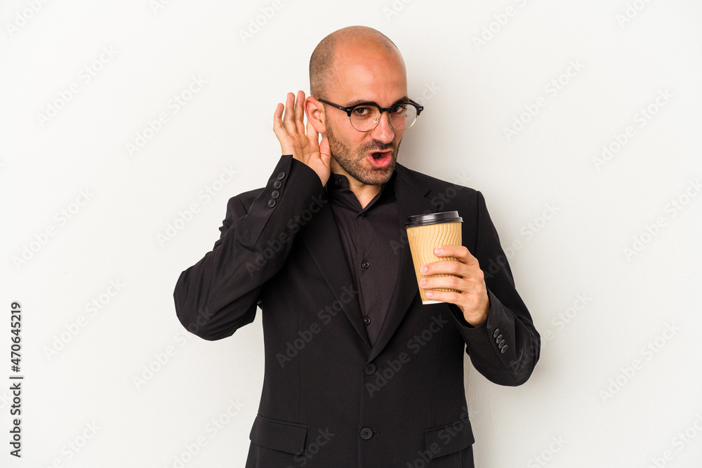 Young business bald man holding take away coffee isolated on white background trying to listening a gossip. Young business bald man holding take away coffee isolated on white background trying to listening a gossip.