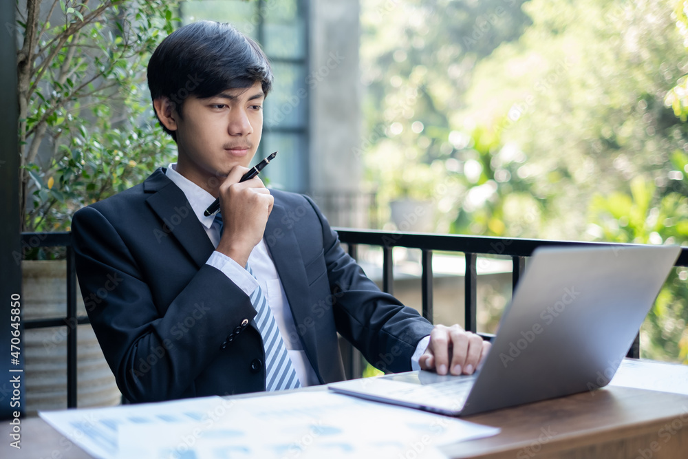 Young Asian businessman financial market analyst sits at their desks and calculate financial graphs showing the results of their investments planning the process of successful business growth Young Asian businessman financial market analyst sits at their desks and calculate financial graphs showing the results of their investments planning the process of successful business growth