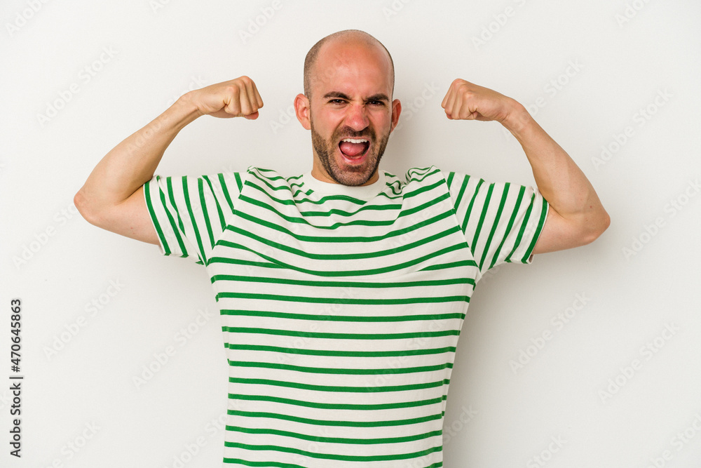 Young bald man isolated on white background showing strength gesture with arms, symbol of feminine power Young bald man isolated on white background showing strength gesture with arms, symbol of feminine power