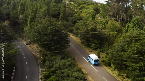 Aerial follows a VW-Camper van that drives on a empty road on Madeira, Portugal photo