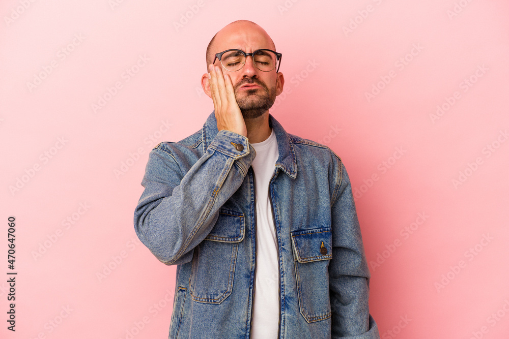 Fototapeta premium Young caucasian bald man isolated on pink background tired and very sleepy keeping hand on head.