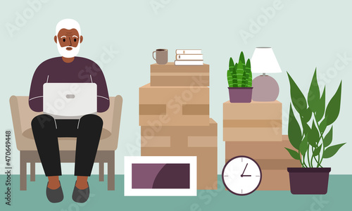 Grandfather at home with a laptop sits in a chair. The concept of online registration of delivery of boxes, goods and assistance in moving.