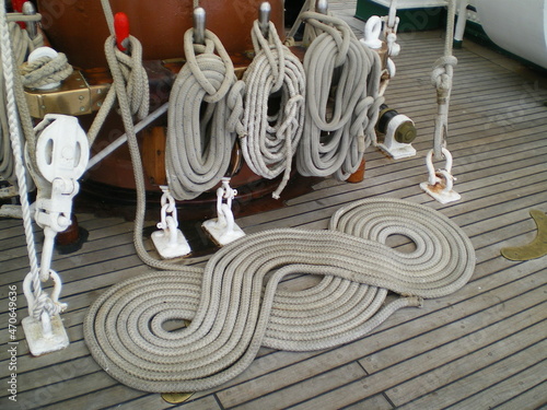 	 Des cordages d'un grand bateau à voile bien rangées, nouées, enroulés, de la bonne organisation de l'équipage, du bon rangement, sur le pont tout en bois photo