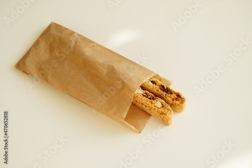 Cantucci cookies with candied fruits and nuts in a paper bag. White background, copy space