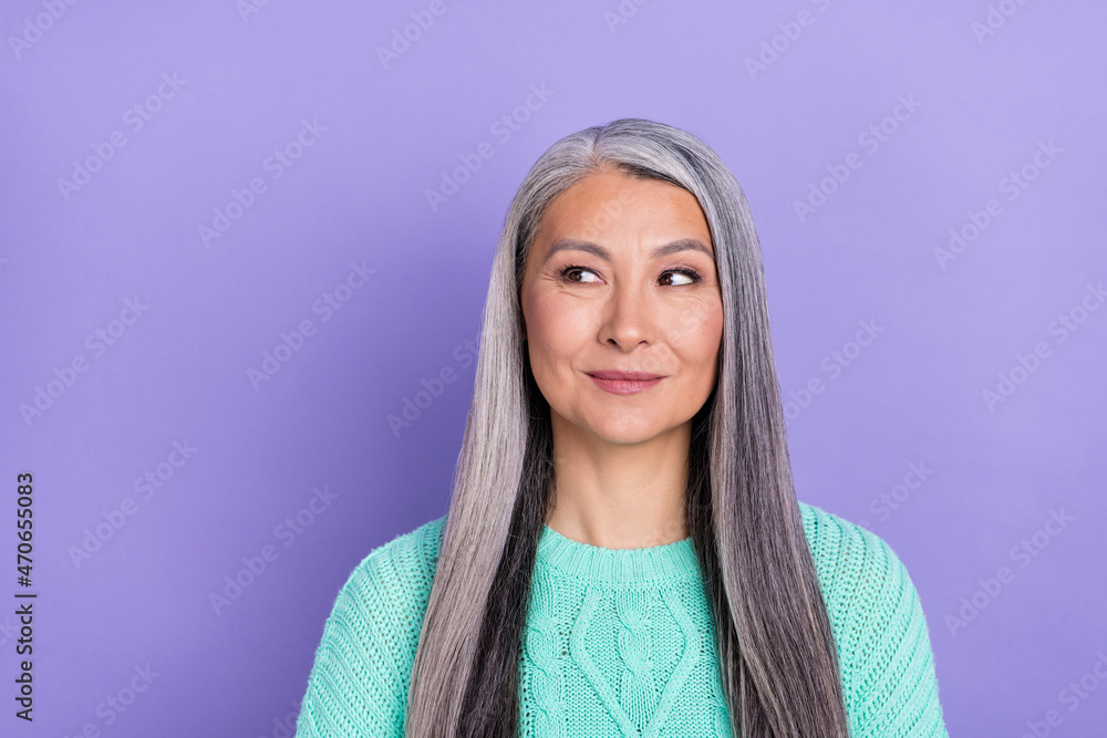 Photo of mature attractive woman wondered look empty space think plan isolated over violet color background Photo of mature attractive woman wondered look empty space think plan isolated over violet color background