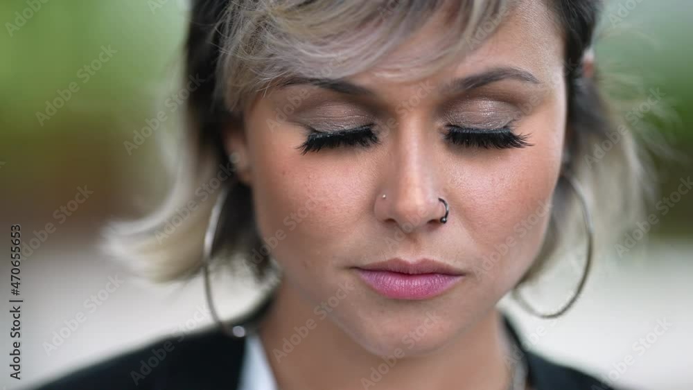 Woman closing eyes in contemplation and opening eyes smiling close-up face Woman closing eyes in contemplation and opening eyes smiling close-up face