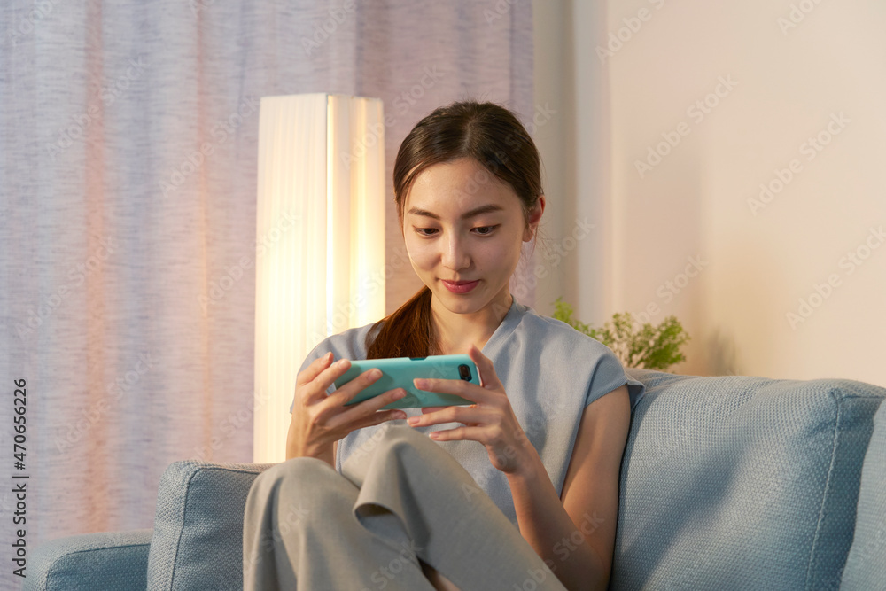 女性　スマホ　リビング　夜