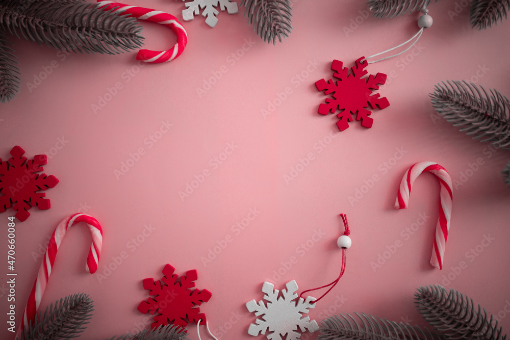 Christmas frame with striped lollipops, Christmas tree branches, wooden decorations on a pink background. Free space, copy space, viva magenta Christmas frame with striped lollipops, Christmas tree branches, wooden decorations on a pink background. Free space, copy space, viva magenta