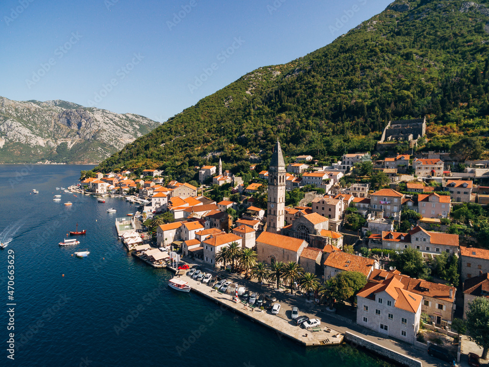 Drone view of the Perast coast with ancient houses and a tower. Montenegro