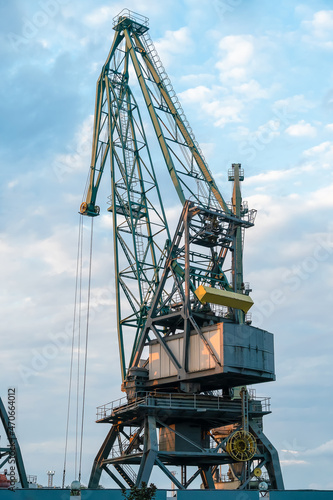 Wallpaper Mural Close-up of a port crane against a beautiful blue sky with clouds before sunset. Cargo terminal. Batumi, Georgia. Vertical photo Torontodigital.ca