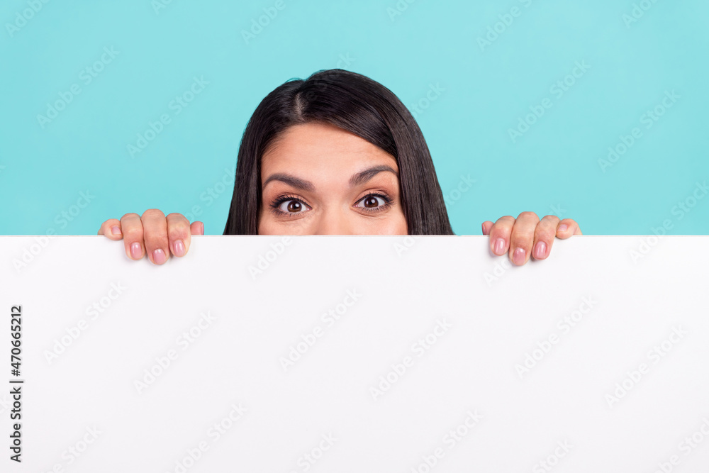 Photo of sweet funny mature woman hiding behind huge empty space isolated turquoise color background Photo of sweet funny mature woman hiding behind huge empty space isolated turquoise color background